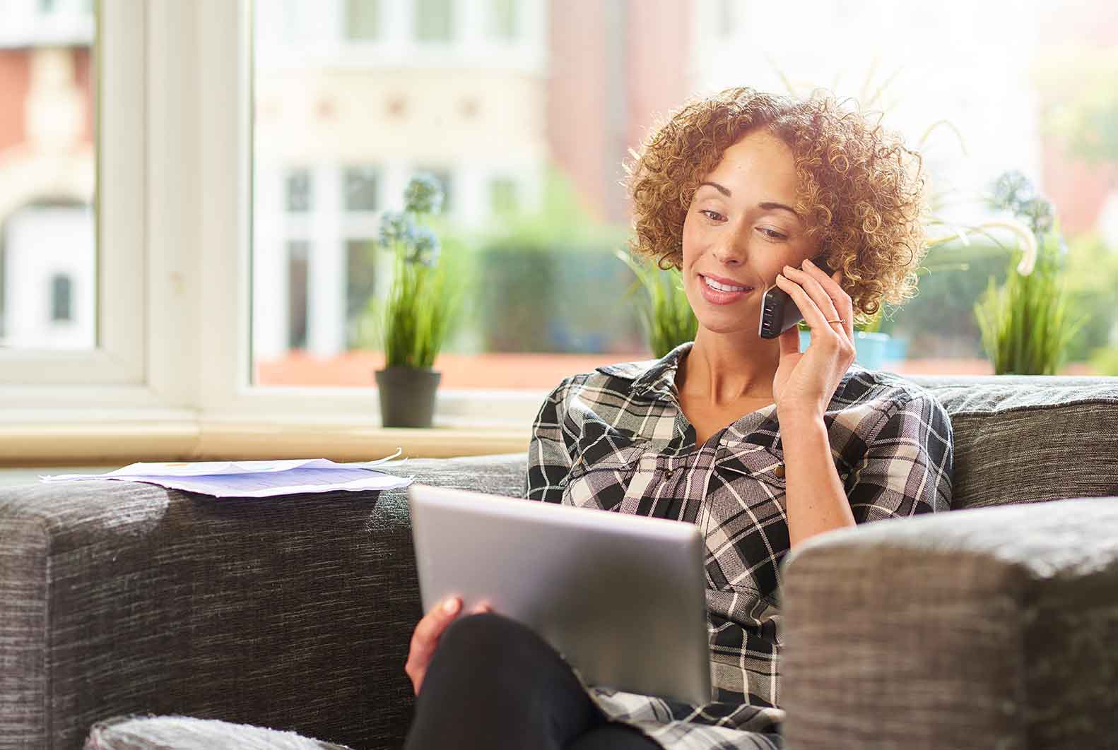 Woman sitting on couch talking on home phone